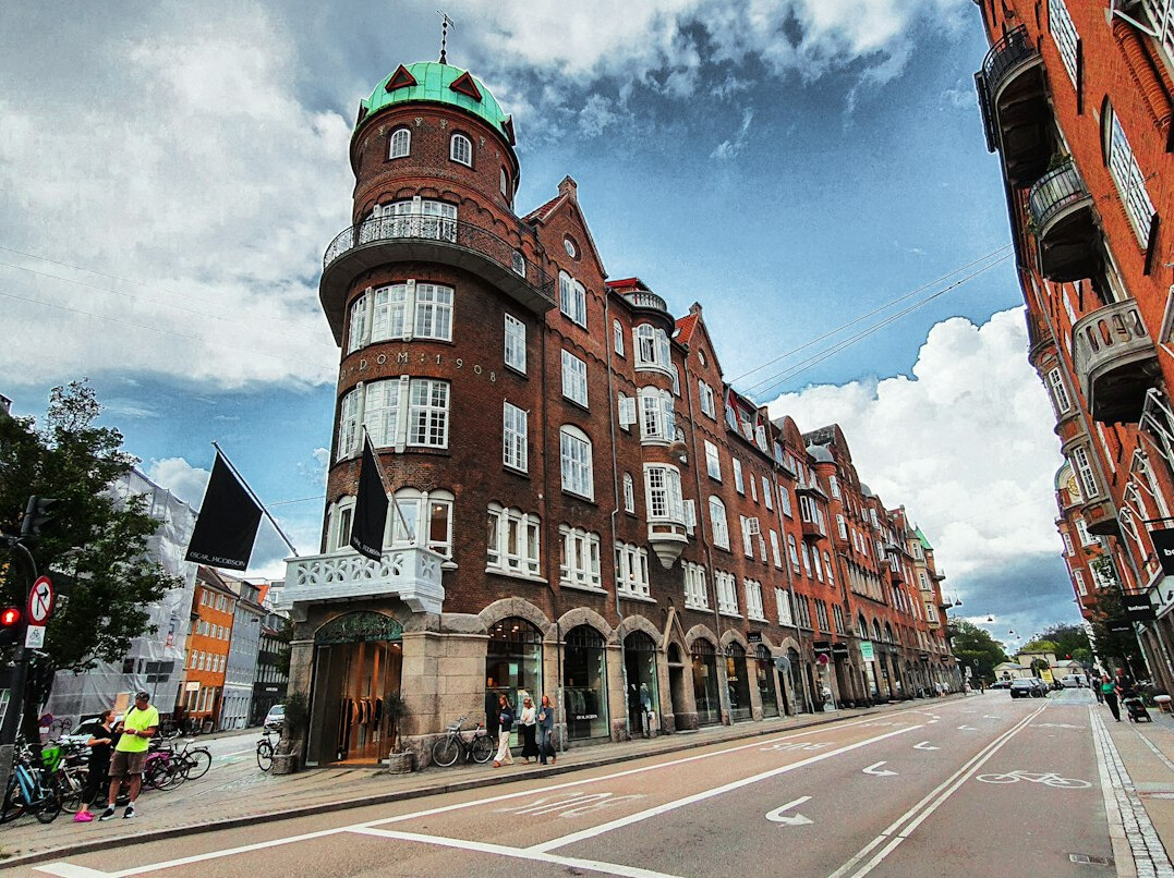 Danish man cycling down a cobbled city street